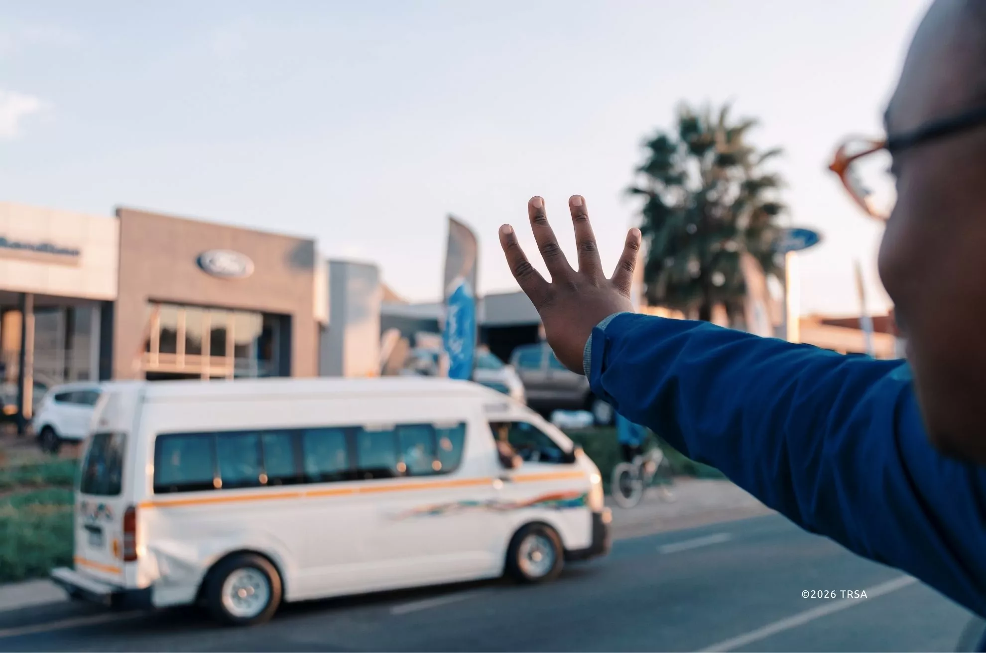 A commuter signalling to a South African minibus taxi
